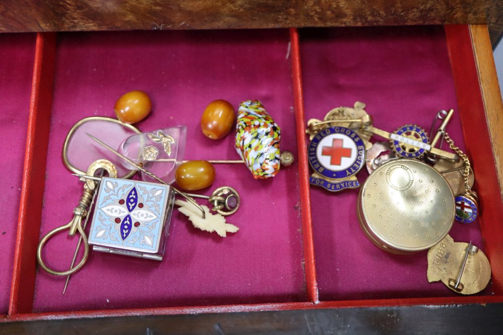 A walnut toilet box, containing four bottles and assorted badges and jewellery etc.